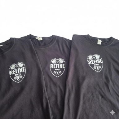 Drei schwarze T-Shirts mit einem Logo und dem Wort „REFINE“ auf der Vorderseite.