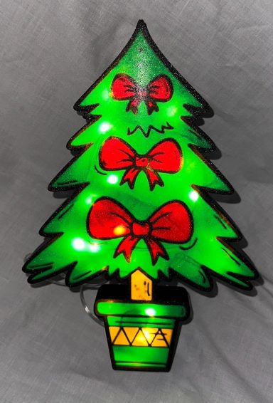 Ein leuchtender Weihnachtsbaum mit roten Schleifen in einem Pflanzgefäß.