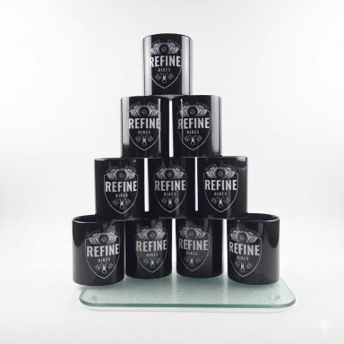 Zehn schwarze Becher mit dem Schriftzug "REFINE" in einer Pyramide angeordnet.