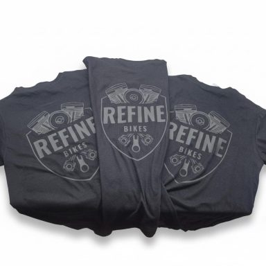 Drei schwarze T-Shirts mit dem Aufdruck "REFINE BIKES" und einem grafischen Emblem.