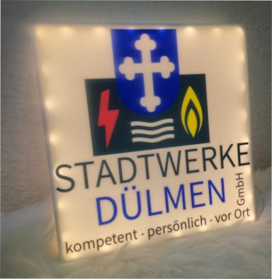 Leuchtendes Schild der Stadtwerke Dülmen mit Logo und Slogan.